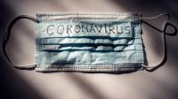 Coronamaske med coronavirus skrevet på